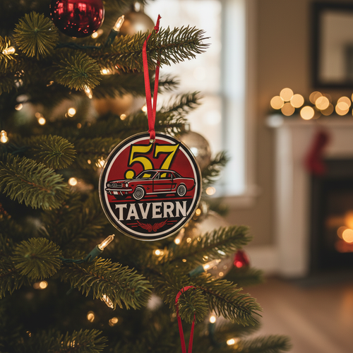 A round Christmas ornament hanging from a decorated Christmas tree in a cozy living room. The ornament features a vintage-style red sign with the text “57 TAVERN” and an illustration of a red car.