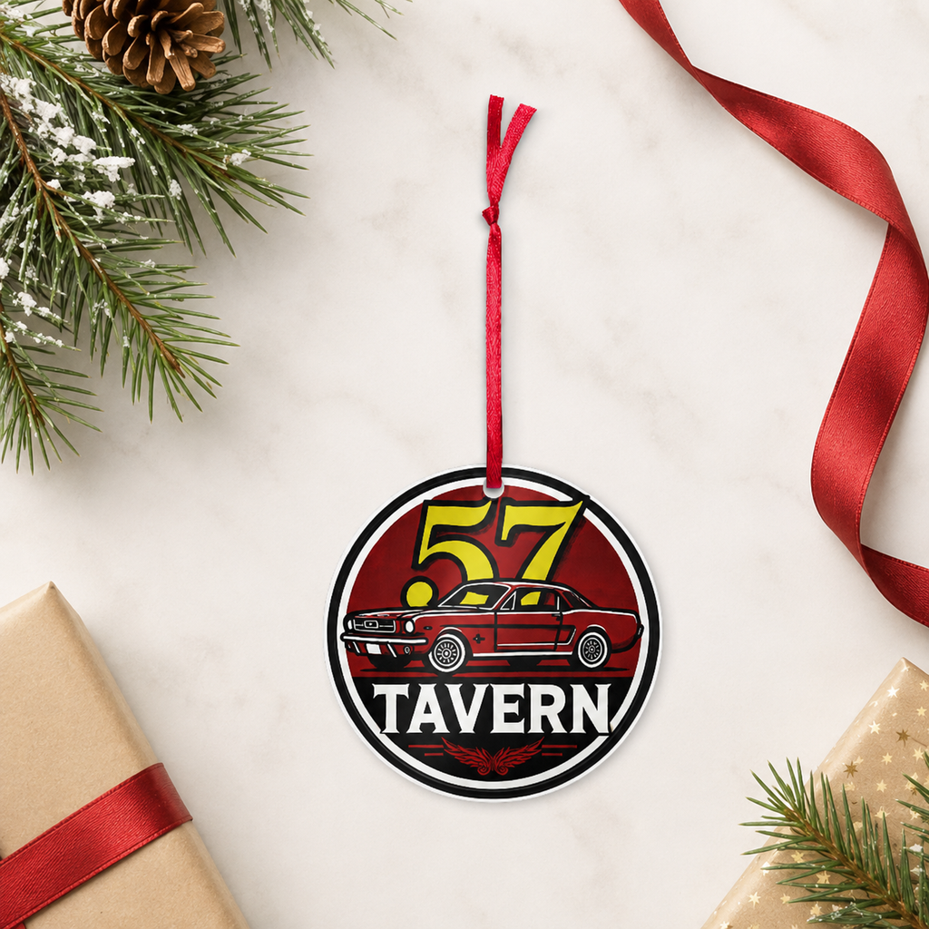 A round hanging ornament with a red ribbon loop, featuring a red car and the words “57 TAVERN,” styled on a light marble surface with pine branches, a pinecone, wrapped gifts, and a red ribbon.