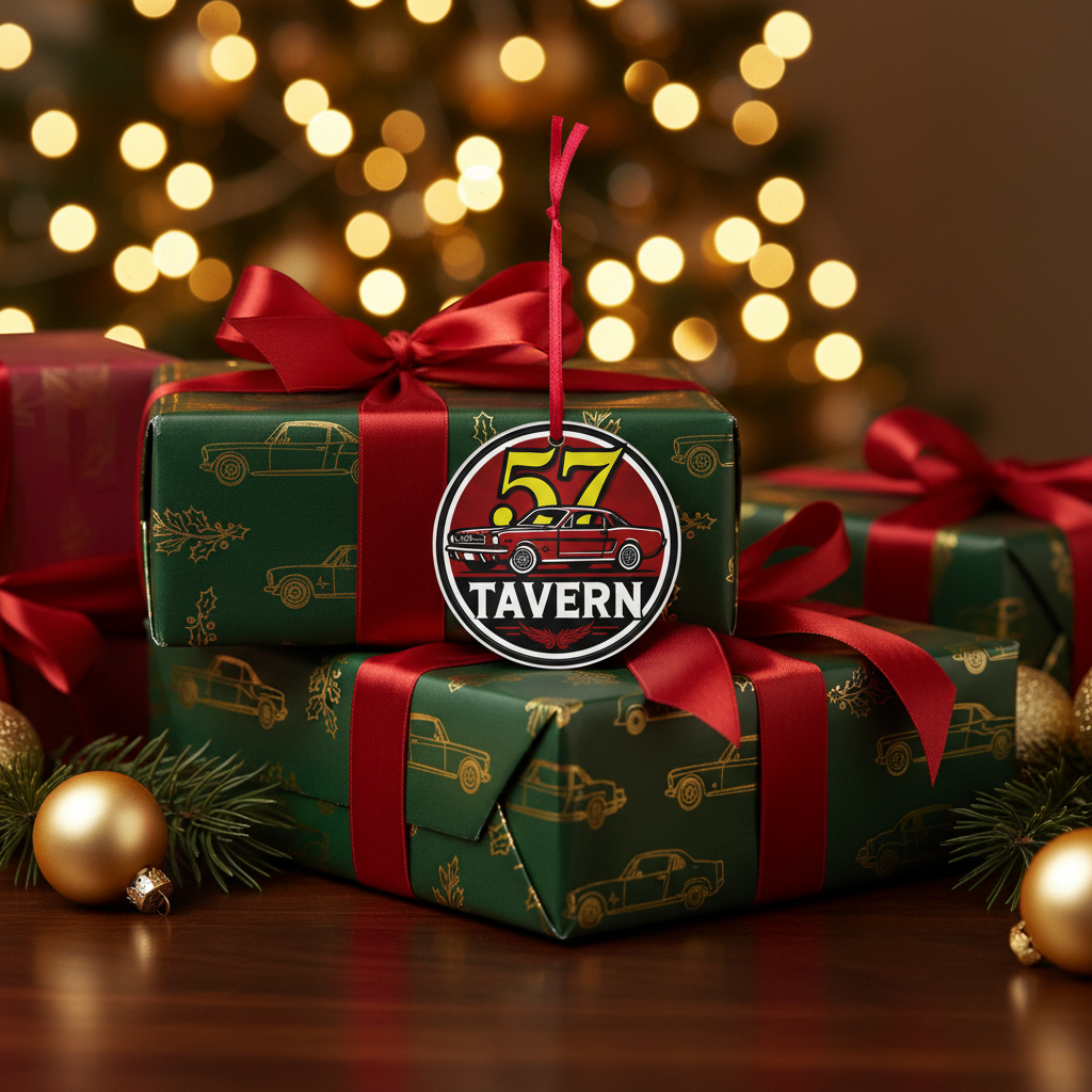 A round Christmas ornament featuring a red and yellow '57 Tavern' logo, hanging from a red ribbon on a green patterned Christmas gift box with gold car motifs, surrounded by other wrapped presents, pine branches, and warm bokeh lights in the background.