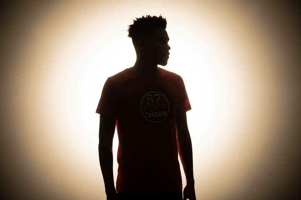 Silhouette of a person wearing a red t-shirt with a logo against a bright background