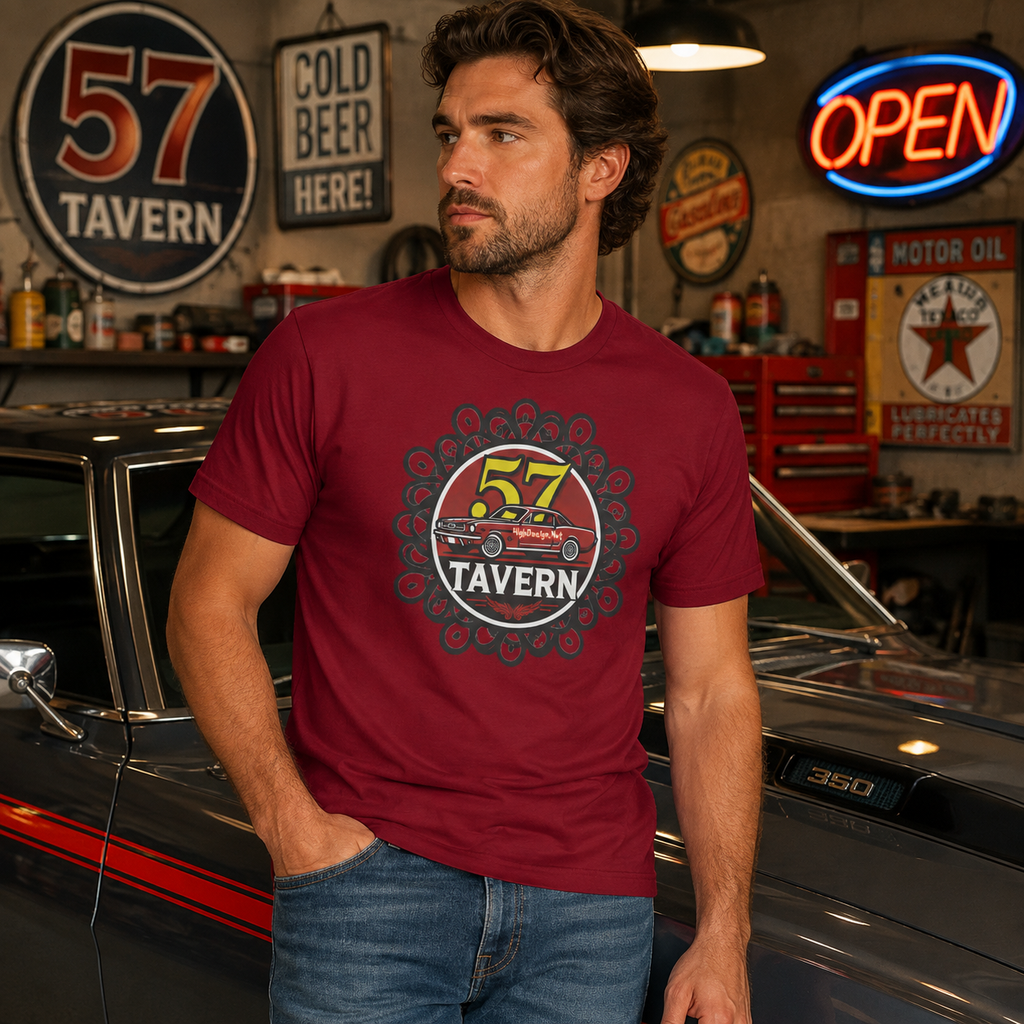 A man wearing a maroon graphic t-shirt with a '57 TaVERN' car logo, standing in a garage setting next to a classic car.