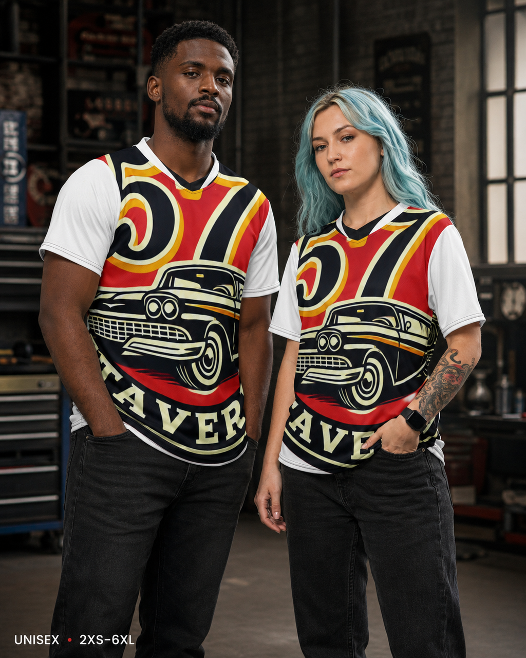 Two models wearing matching graphic t-shirts in a garage setting. The shirts feature a white base with a large red, yellow, and black retro car design and the word 'RAVER' printed below.