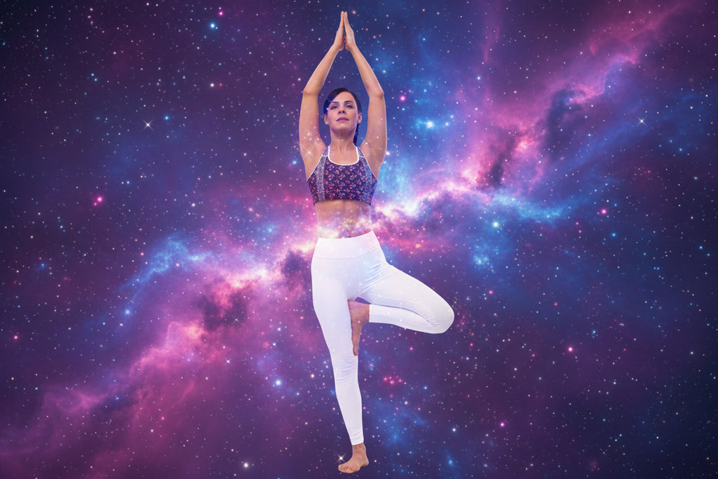 Woman in colorful sports bra and white leggings performing a yoga pose on a white background