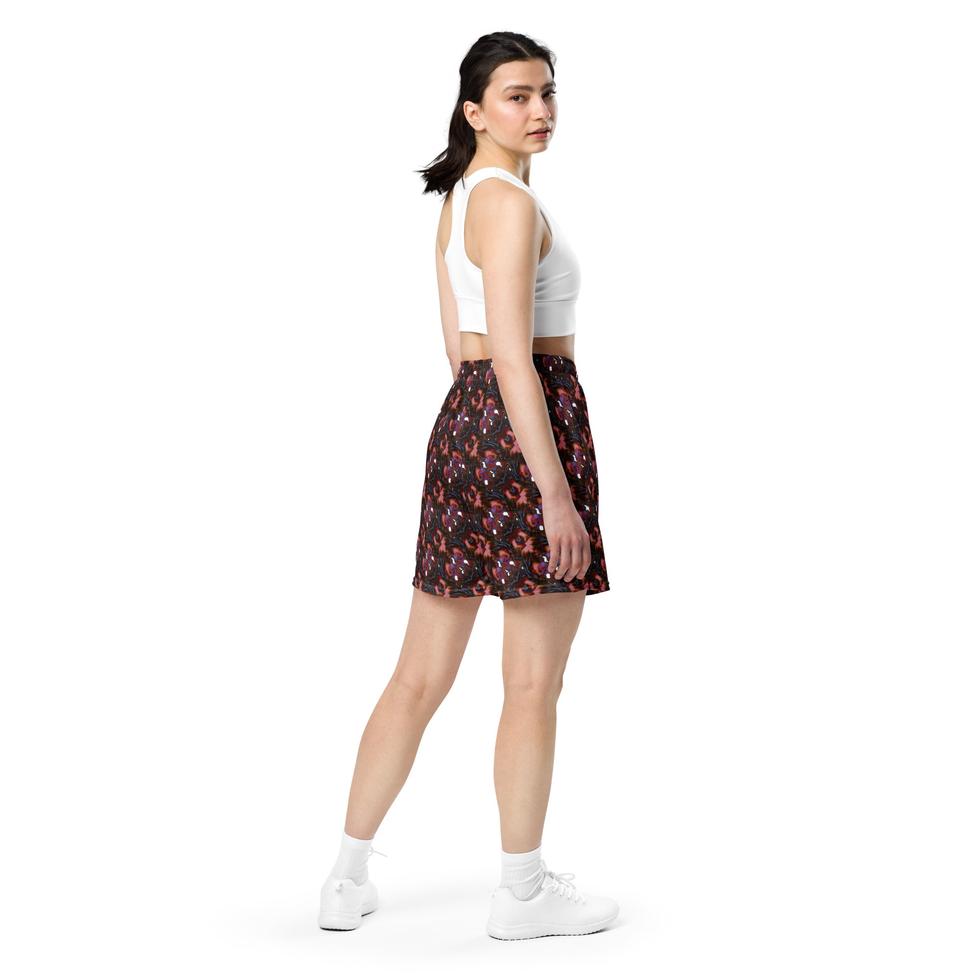Woman wearing a white crop top and patterned skirt on a white background