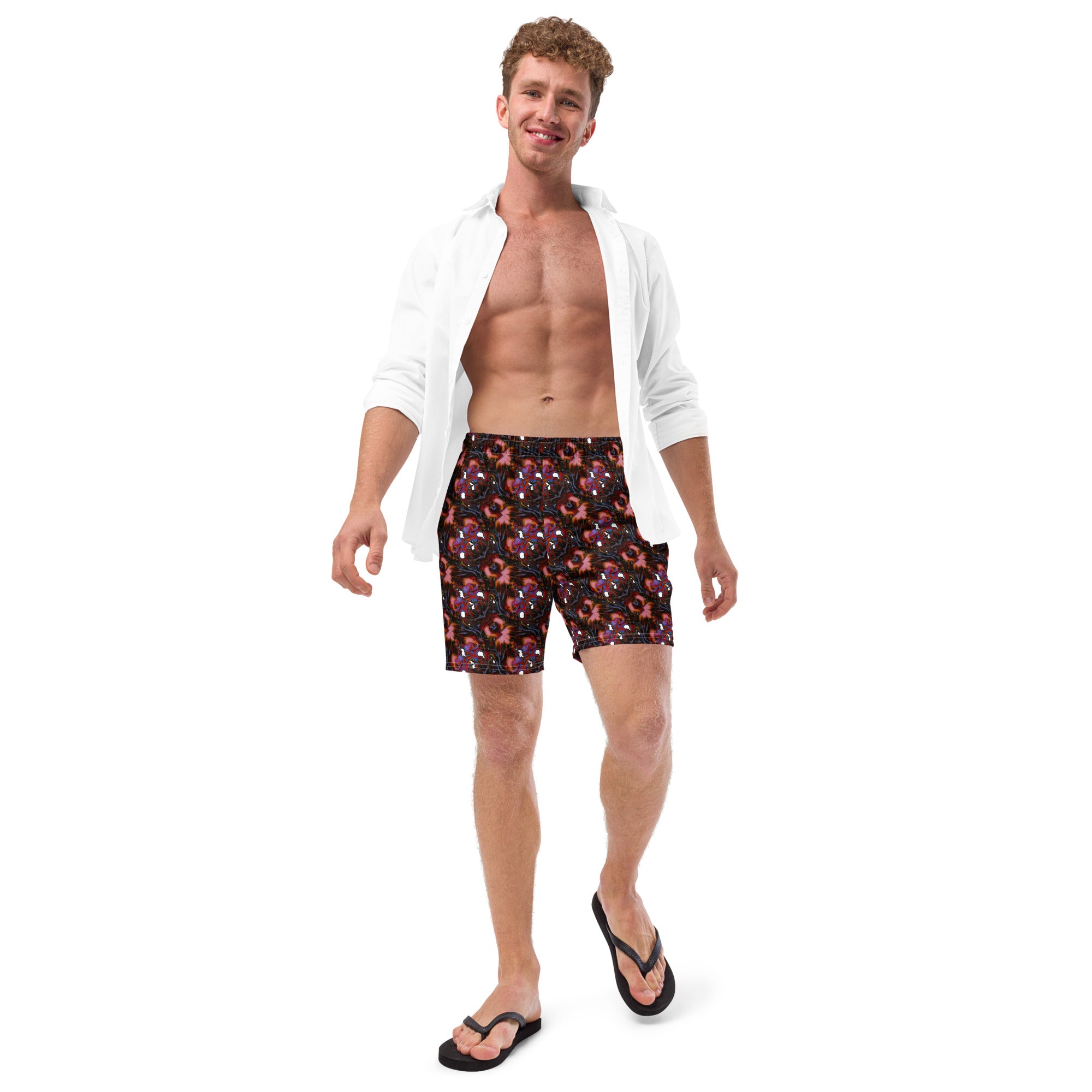 Man wearing red swim shorts with white polka dots and a white shirt on a white background