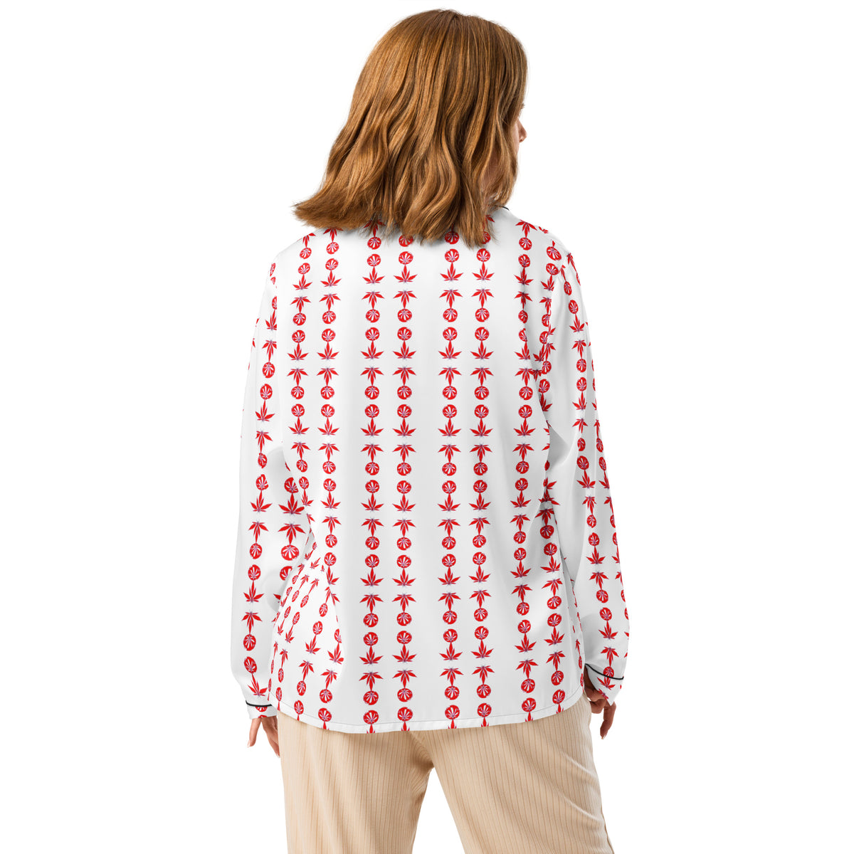 A woman wearing a long sleeve pajama top with a chest pocket and decorative piping detail. The top is white with a red anchor pattern.