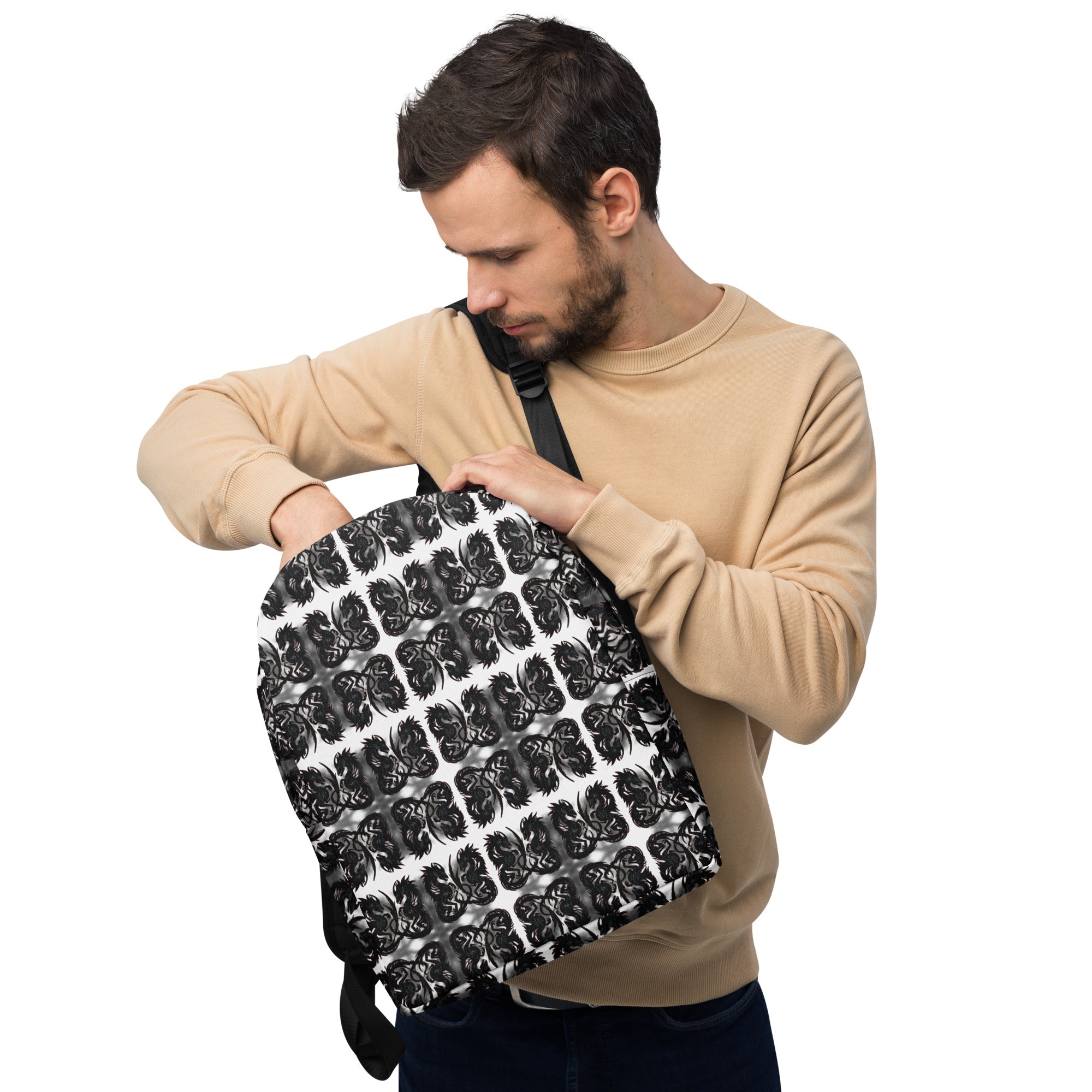 Man holding a black and white patterned backpack against a white background