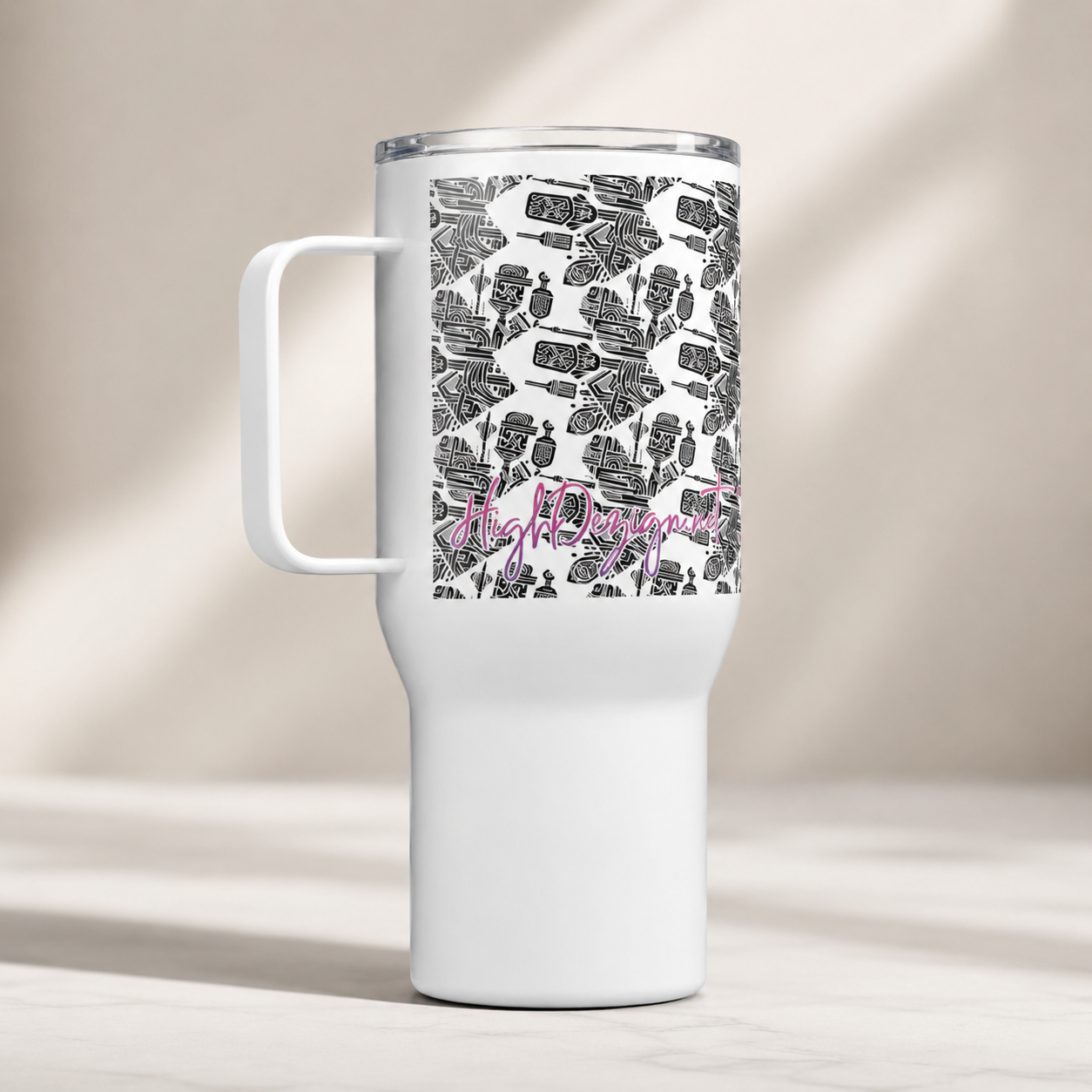 A white insulated travel tumbler with a clear lid and handle, featuring a black patterned wrap around the upper half with the word 'highachiever' in pink script, shown on a light beige background.