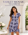 A woman modeling a short wrap-style dress with a blue and white geometric mosaic pattern, standing in a bright white arched doorway. Text at the top reads 'VIOLET MOSAIC TEA DRESS' with size and customization details.