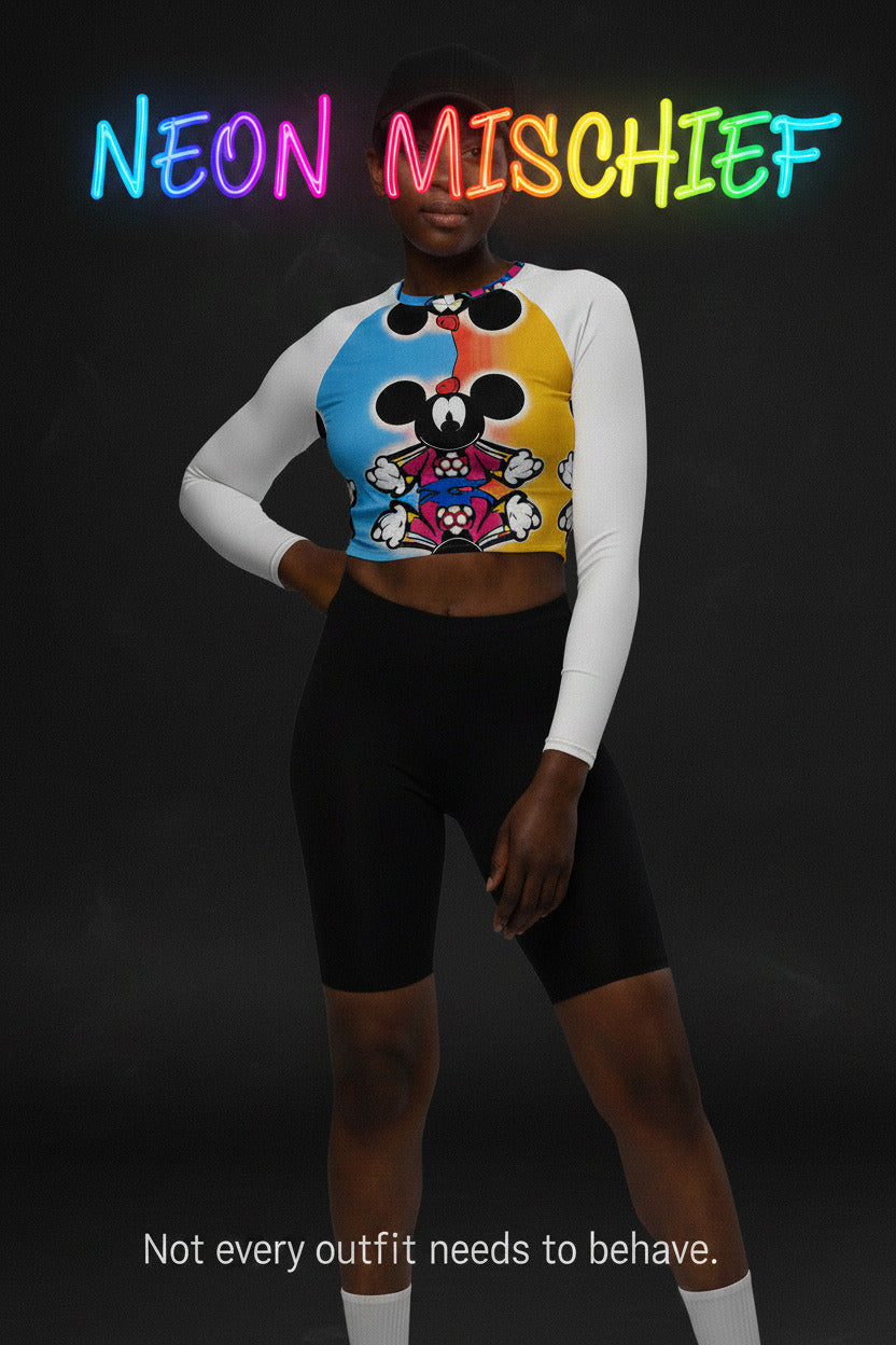 Person wearing a colorful crop top with cartoon character design and black shorts on a white background