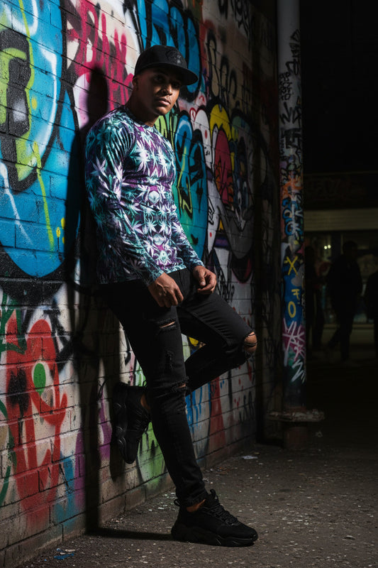 Person leaning against a graffiti-covered wall at night